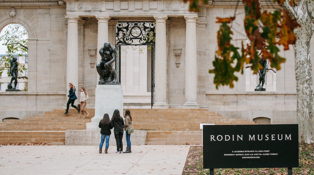 Benjamin Franklin Parkway showing signage and a statue or sculpture as well as a small group of people