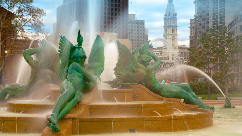 Ein Brunnen mit Cherub-Statuen auf einem Stadtplatz.