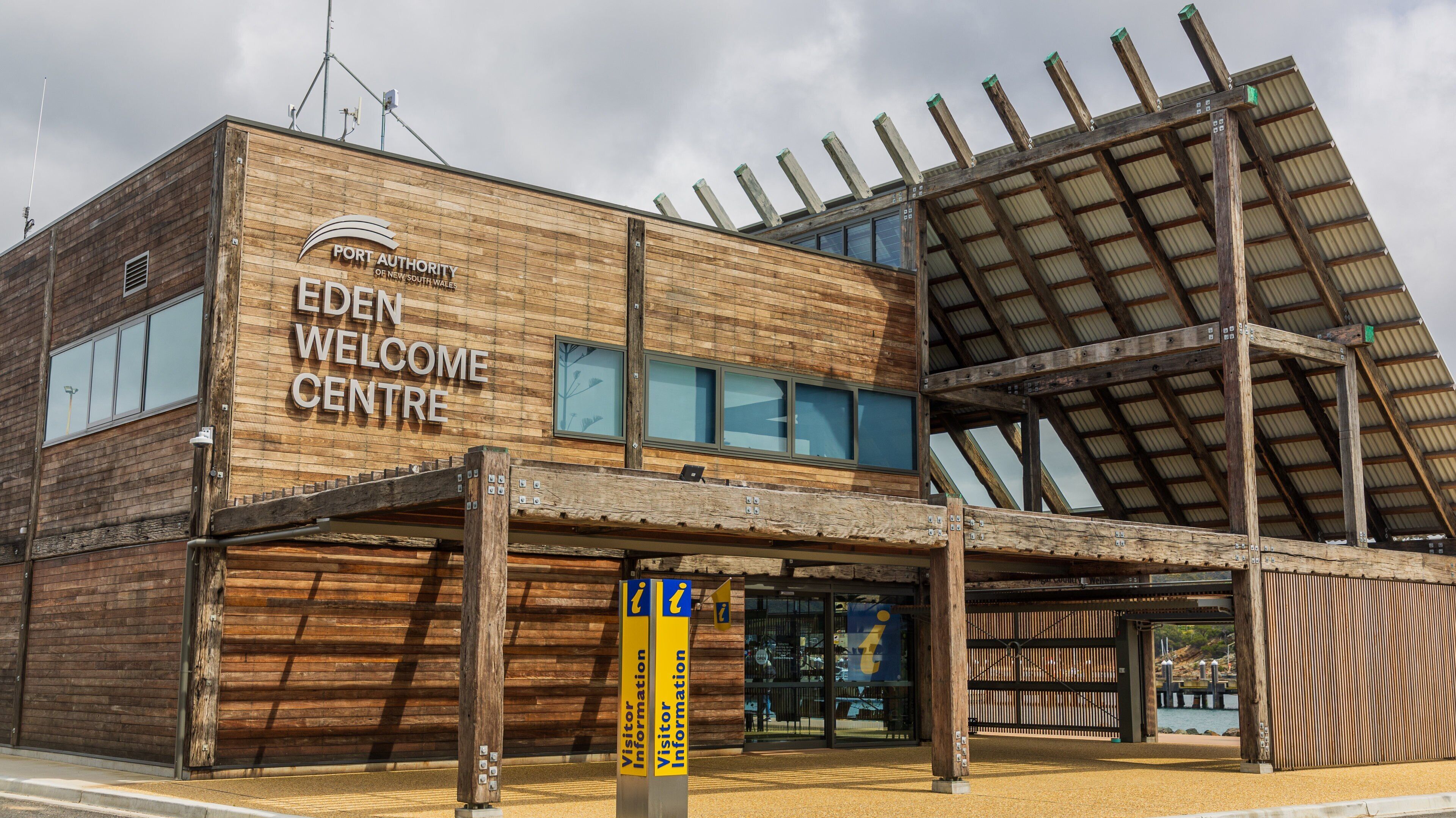 Un bâtiment en bois portant l’inscription « Centre d’accueil de l’autorité portuaire de Nouvelle-Galles du Sud, Eden ».