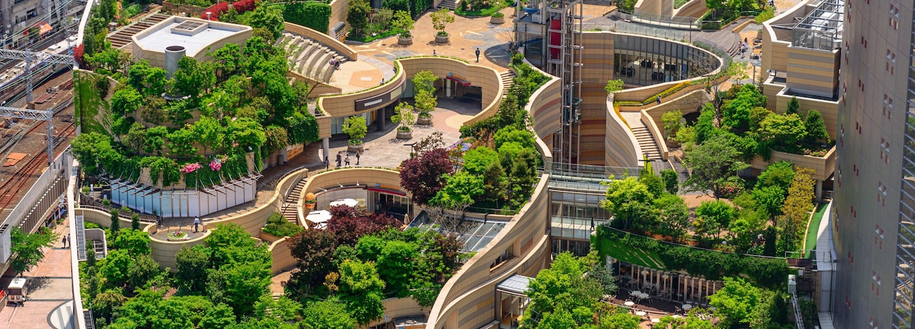 Un quartier urbain moderne, caractérisé par des bâtiments aux lignes courbes, des espaces verts et une place centrale.