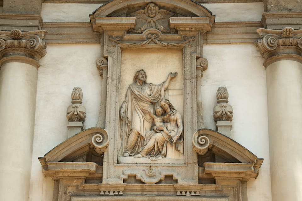 En klassisk arkitektonisk relief med en central figur, omgiven av kolonner och dekorativa element.