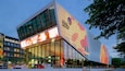 Un bâtiment moderne doté de grands écrans numériques et de fenêtres en verre.
