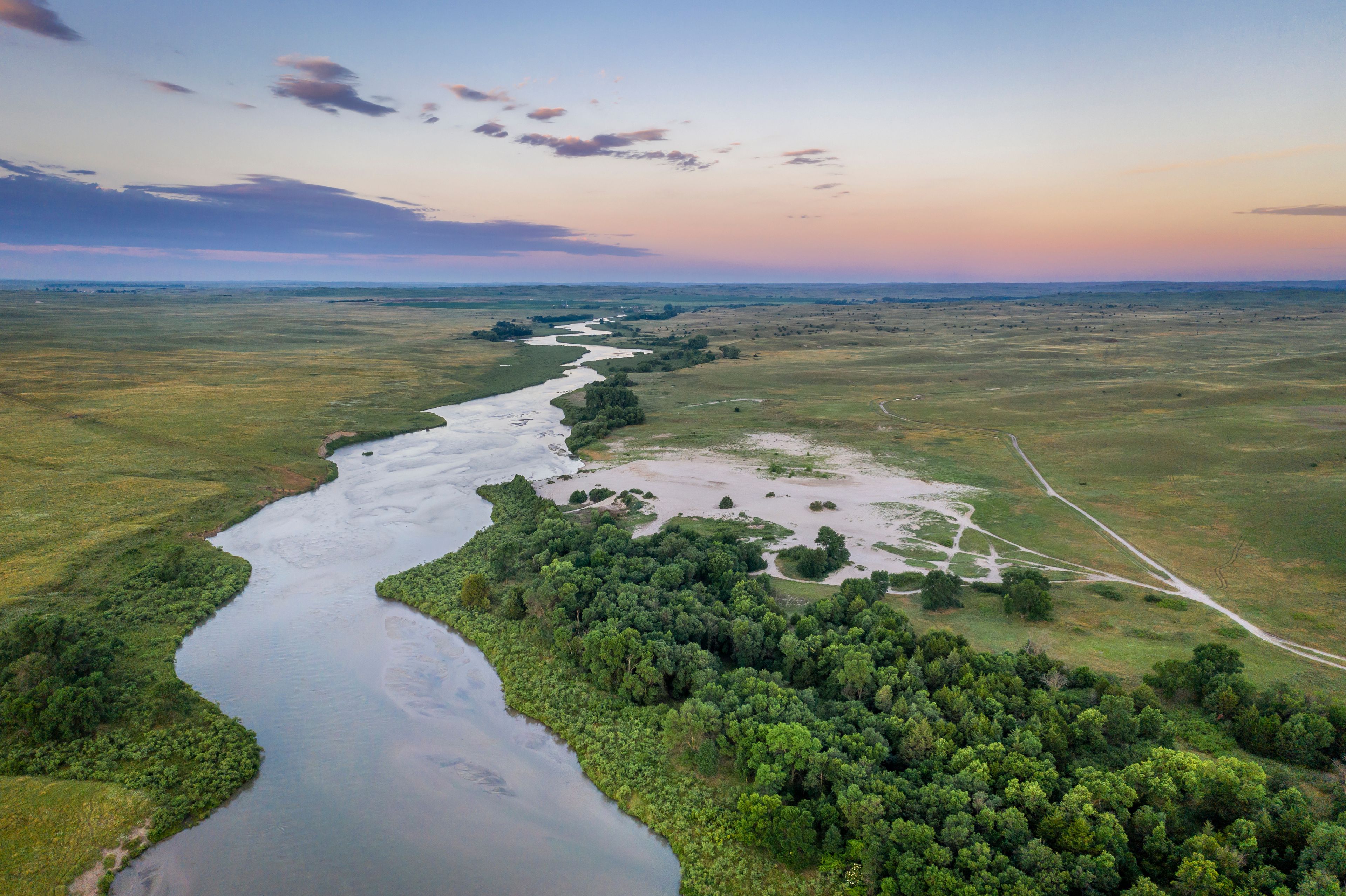 A river winding through a green landscape with a clear sky.