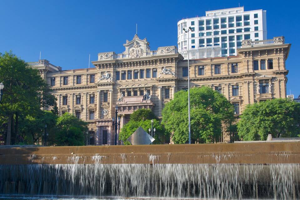 A historic building with ornate architecture and a fountain in the foreground.