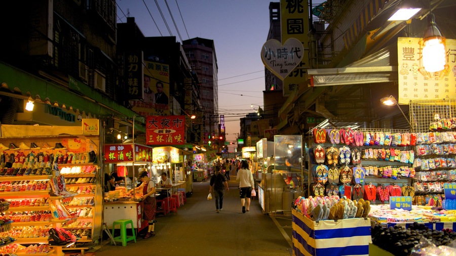 A bustling street market with various shops and stalls selling shoes and souvenirs.