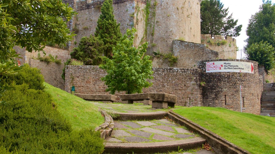 Un sendero de piedra que conduce a un edificio histórico con un cartel que indica un museo.