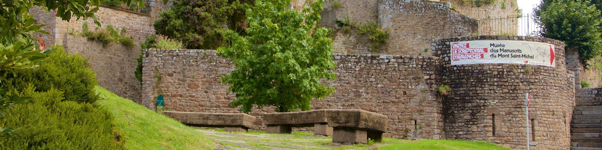 Un sendero de piedra que conduce a un edificio histórico con un cartel que indica un museo.