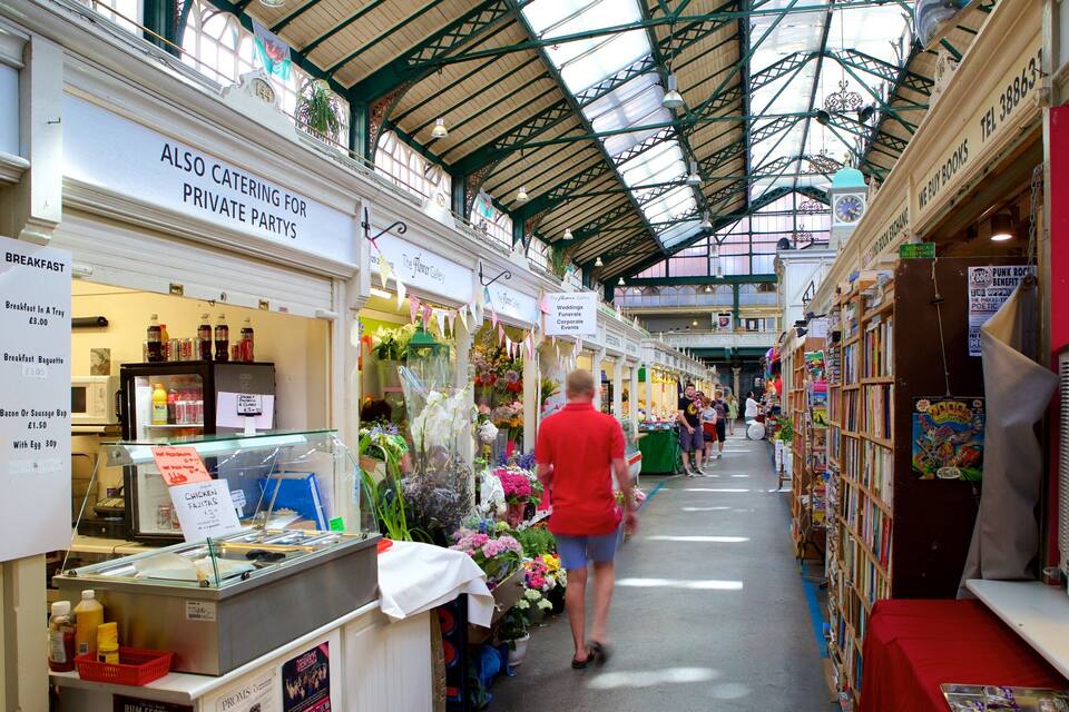 Un mercat interior amb diferents paradetes que venen floristeria, llibres i menjar.