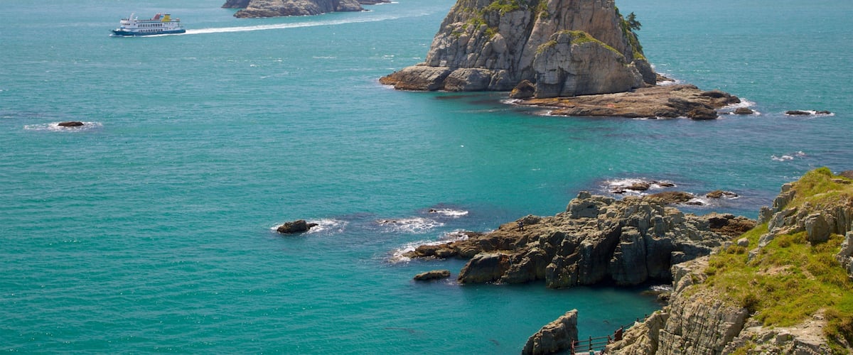 Busan which includes boating, island views and rocky coastline