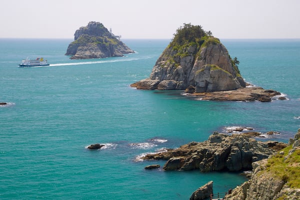 Busan which includes boating, island views and rocky coastline