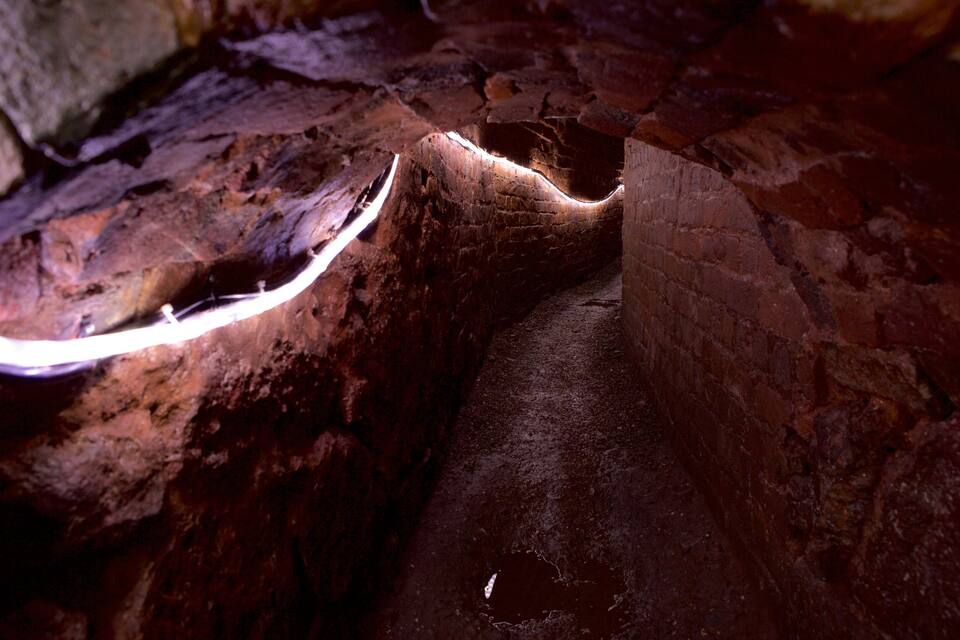 A cave with rough, uneven walls and a narrow passageway.