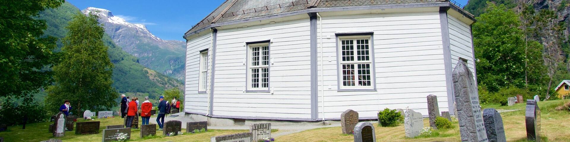 Geiranger featuring a cemetery and a church or cathedral as well as a small group of people
