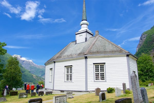 Geiranger welches beinhaltet Kirche oder Kathedrale und Friedhof sowie kleine Menschengruppe