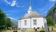 Geiranger featuring a cemetery and a church or cathedral as well as a small group of people