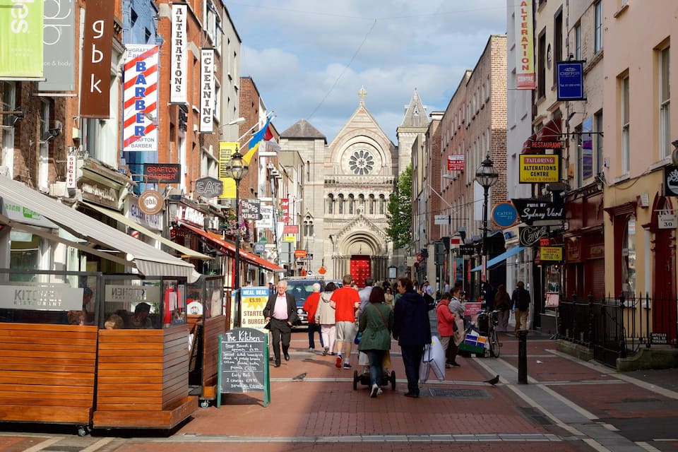 A bustling street with various shops, including a restaurant and a barbershop.