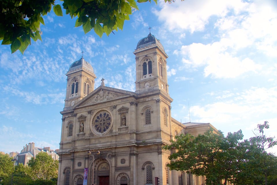 A historic church with two towers and a large clock.