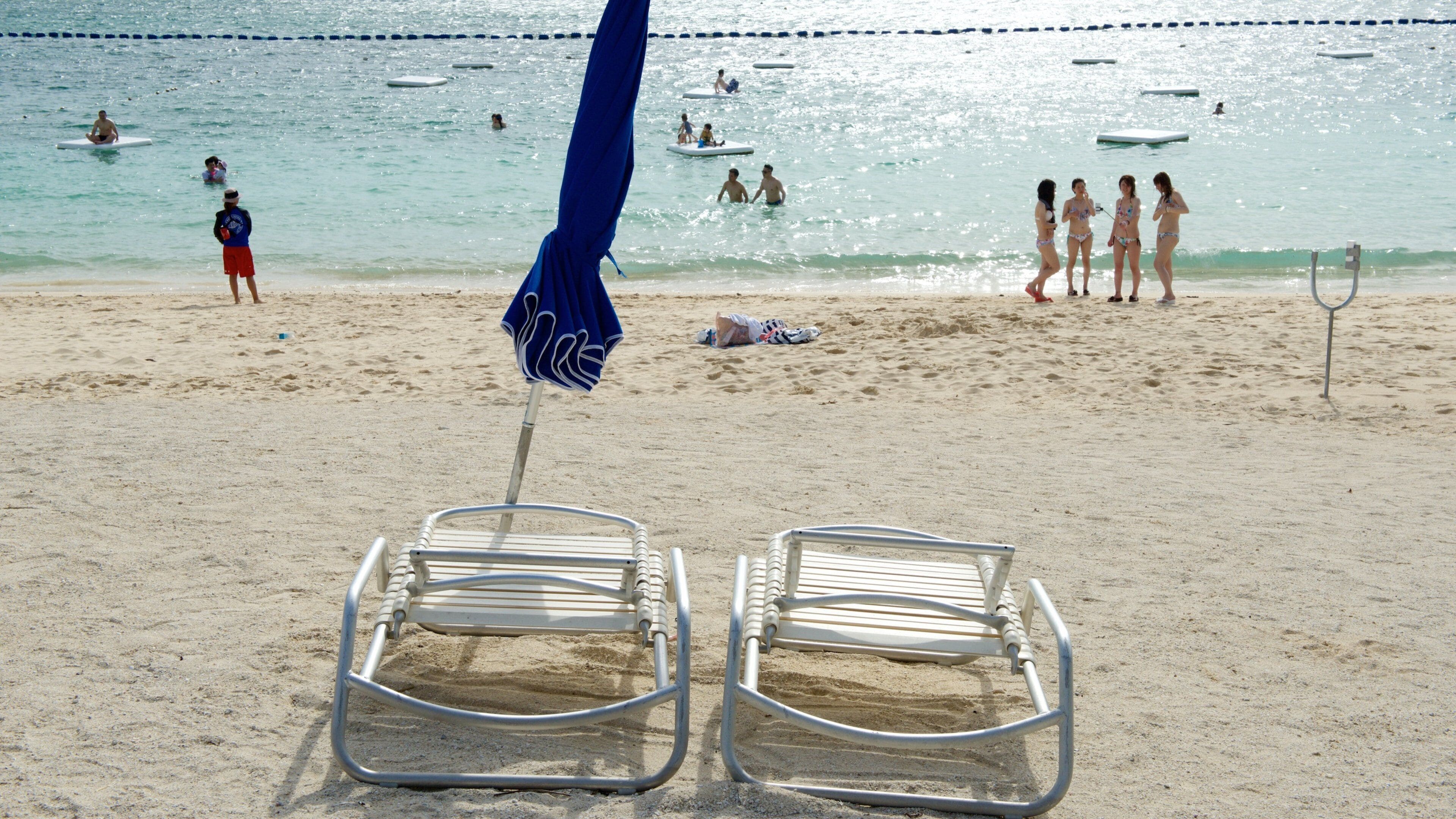 Okinawa featuring swimming and a beach as well as a large group of people