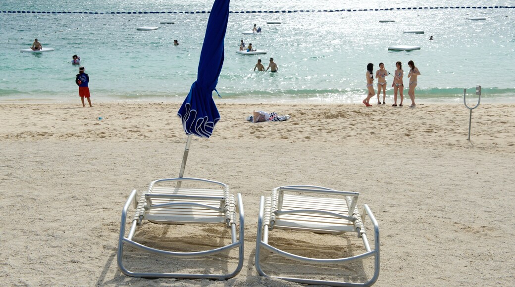 Okinawa featuring swimming and a beach as well as a large group of people