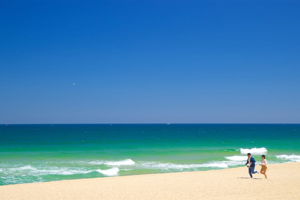 A beach with a clear blue sky and turquoise ocean waves.