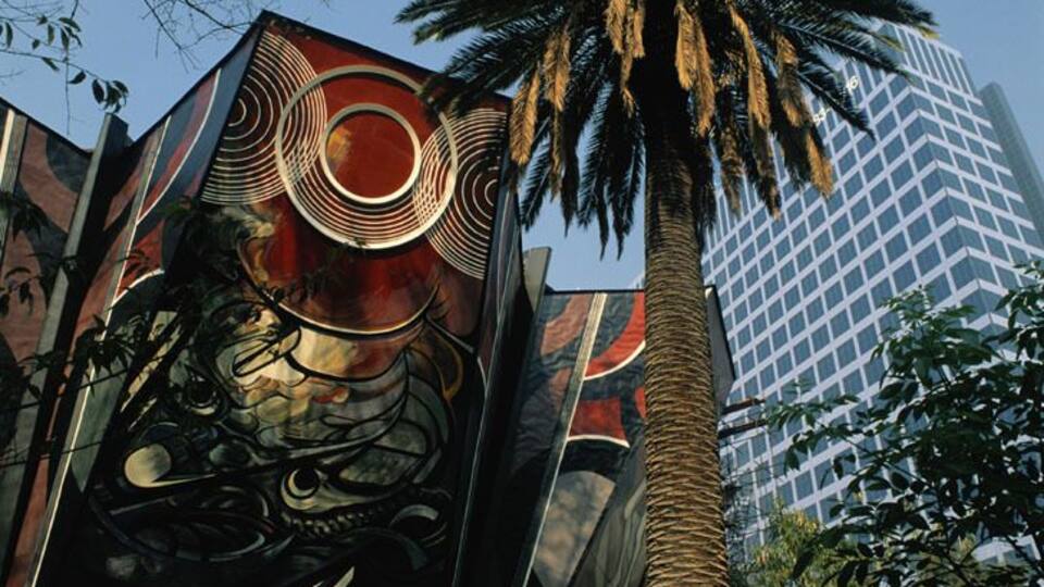 A building with a large mural of a dragon and a palm tree.