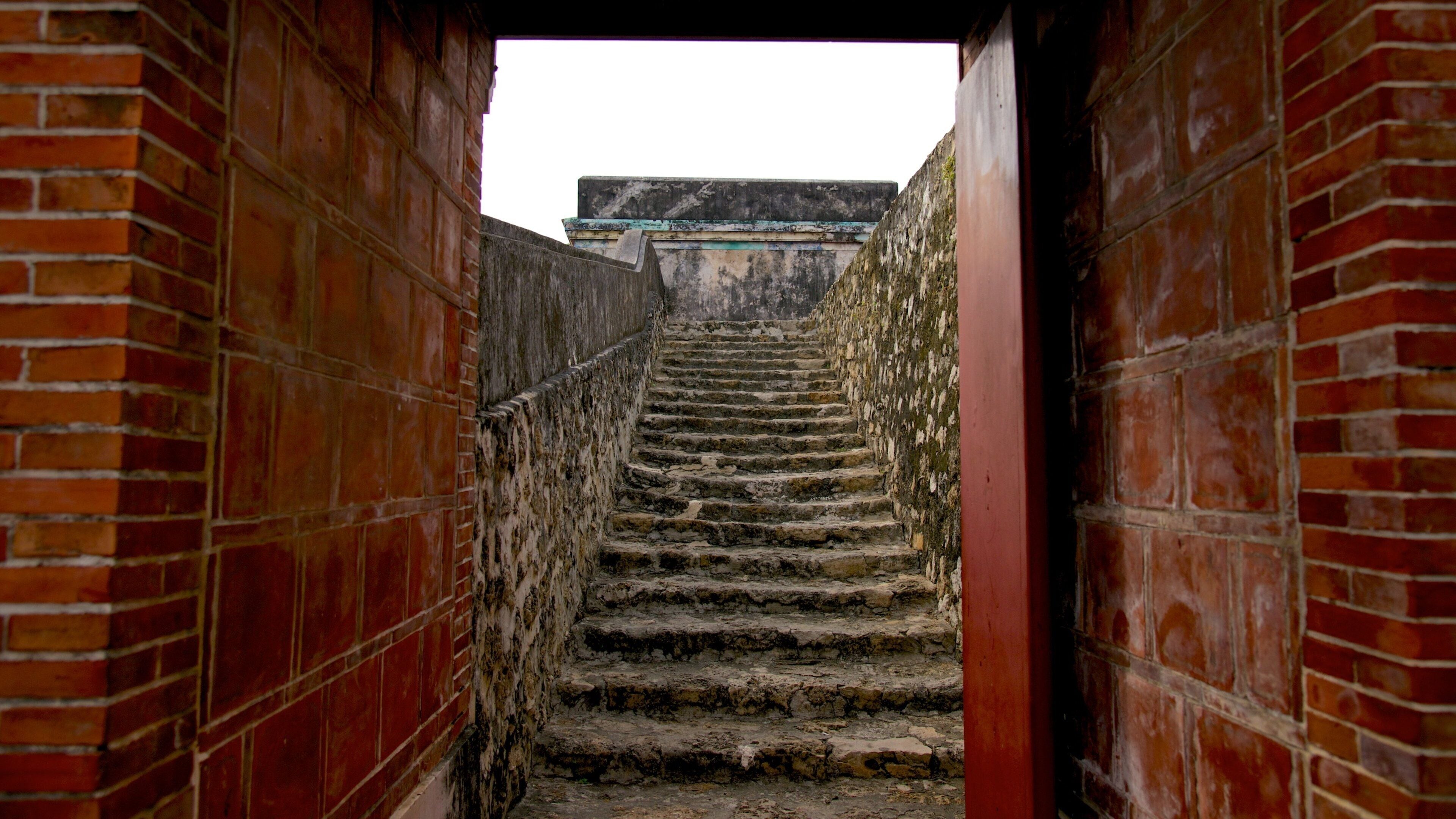 A staircase leading up to a building with a weathered exterior.