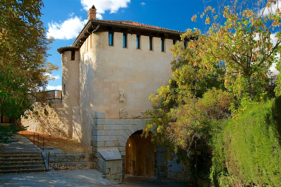 A historic building with a stone facade, a tiled roof, and an arched entrance.
