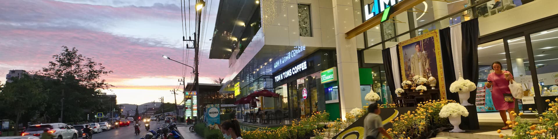 Un centre commercial qui abrite un café appelé « Tom Toms Coffee » et un magasin nommé « MELIGHT ».