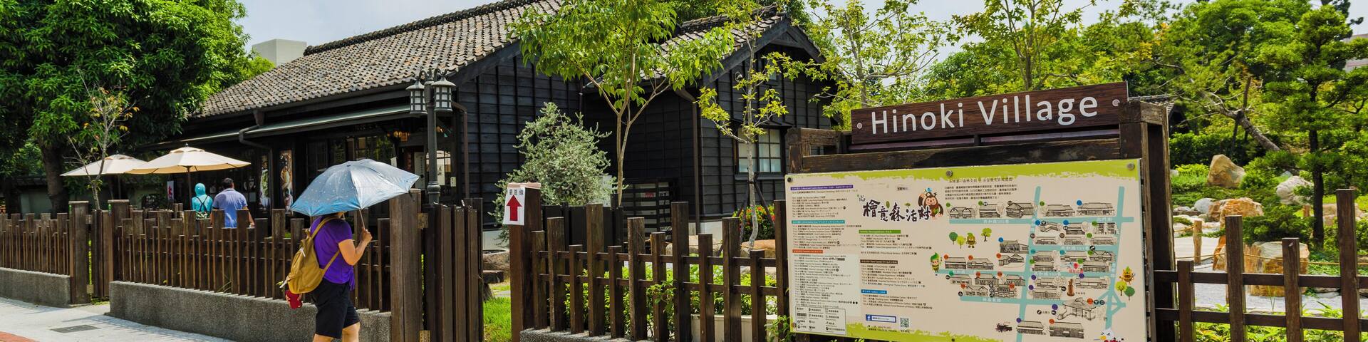 A wooden fence, a sign reading "Hinoki Village," and a map.