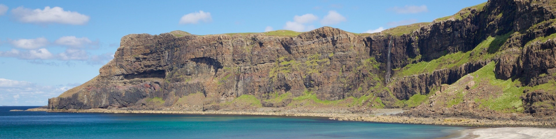 Isle of Skye which includes mountains, rocky coastline and a pebble beach