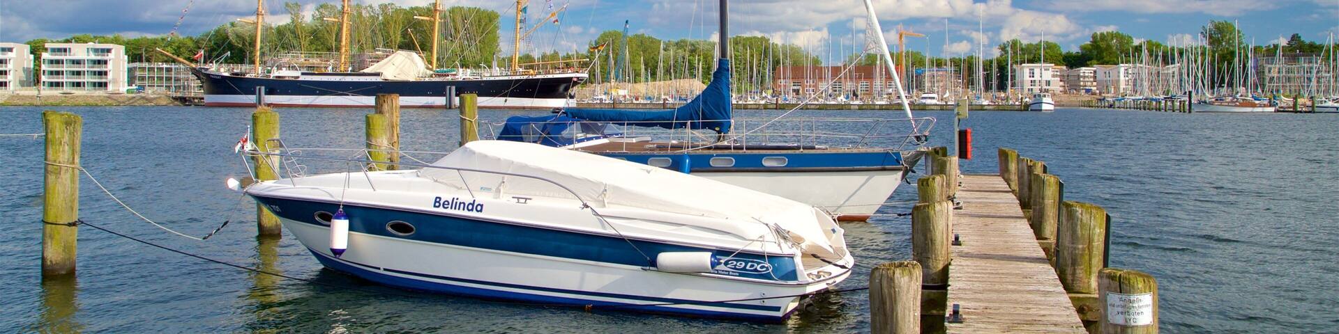 A marina with several sailboats docked at wooden piers.