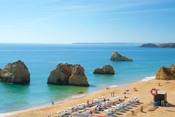 Portimão welches beinhaltet allgemeine Küstenansicht und Felsküste sowie kleine Menschengruppe