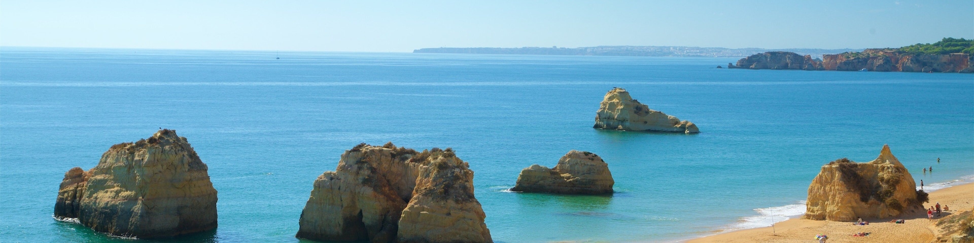 Portimao which includes general coastal views and rugged coastline as well as a small group of people