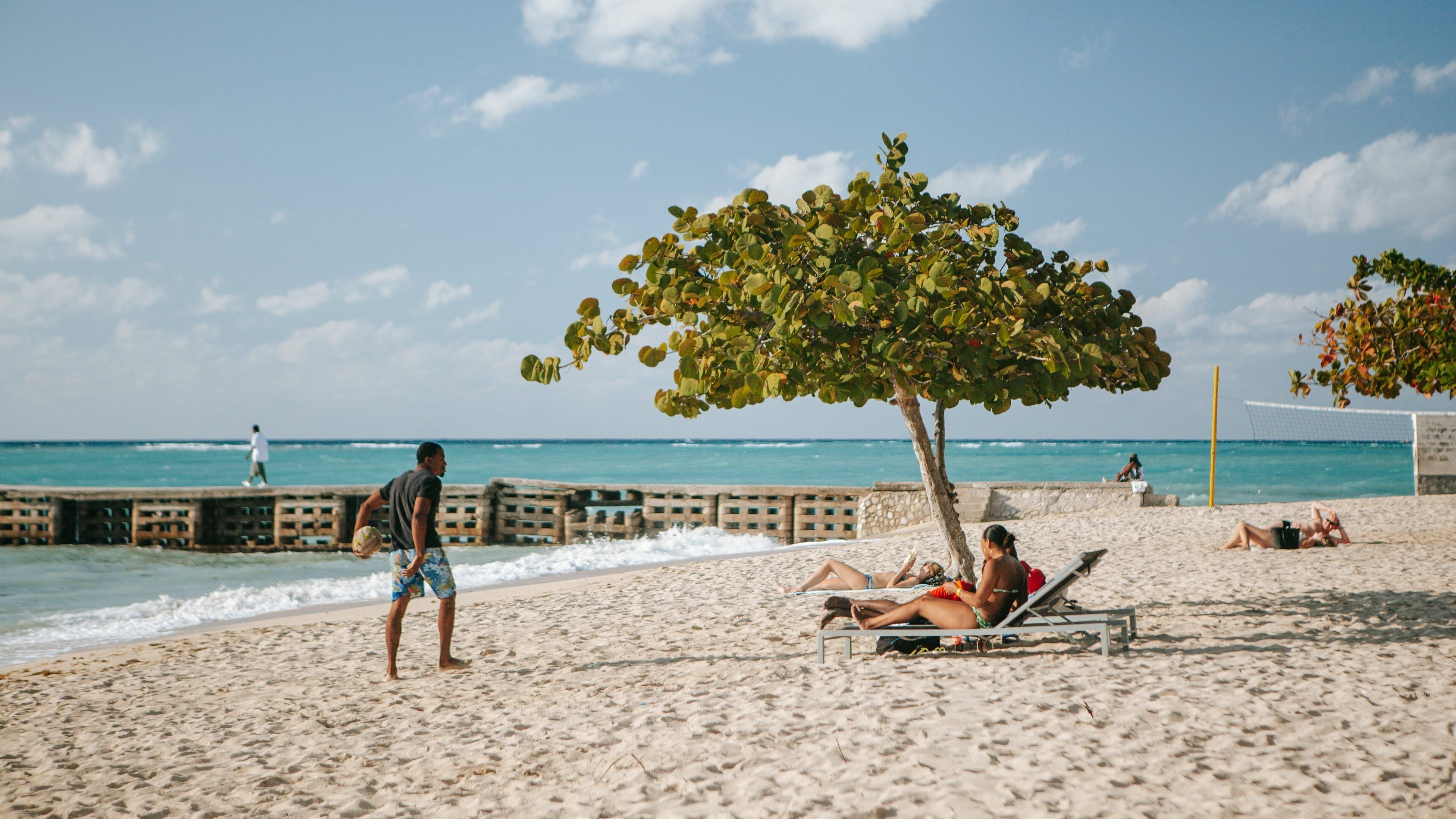 Doctor\'s Cave Beach featuring general coastal views and a sandy beach as well as an individual male