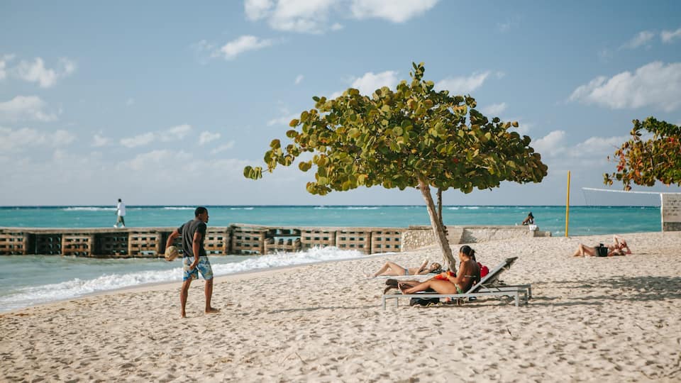 Doctor\'s Cave Beach featuring general coastal views and a sandy beach as well as an individual male