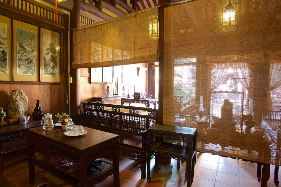 A traditional wooden room with a table, chairs, and a large window.