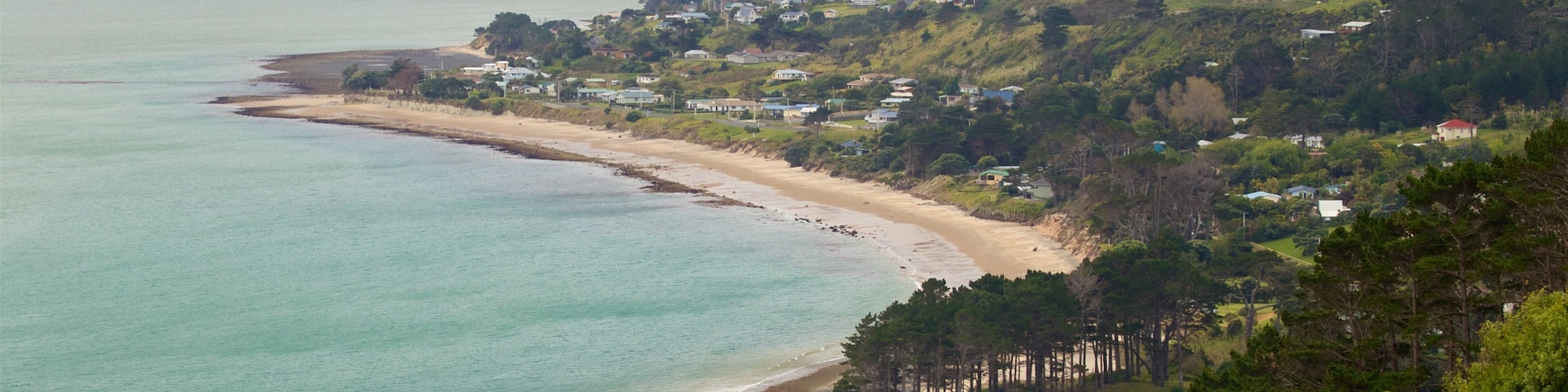 Omapere mostrando una ciudad costera, una playa de arena y vista general a la costa