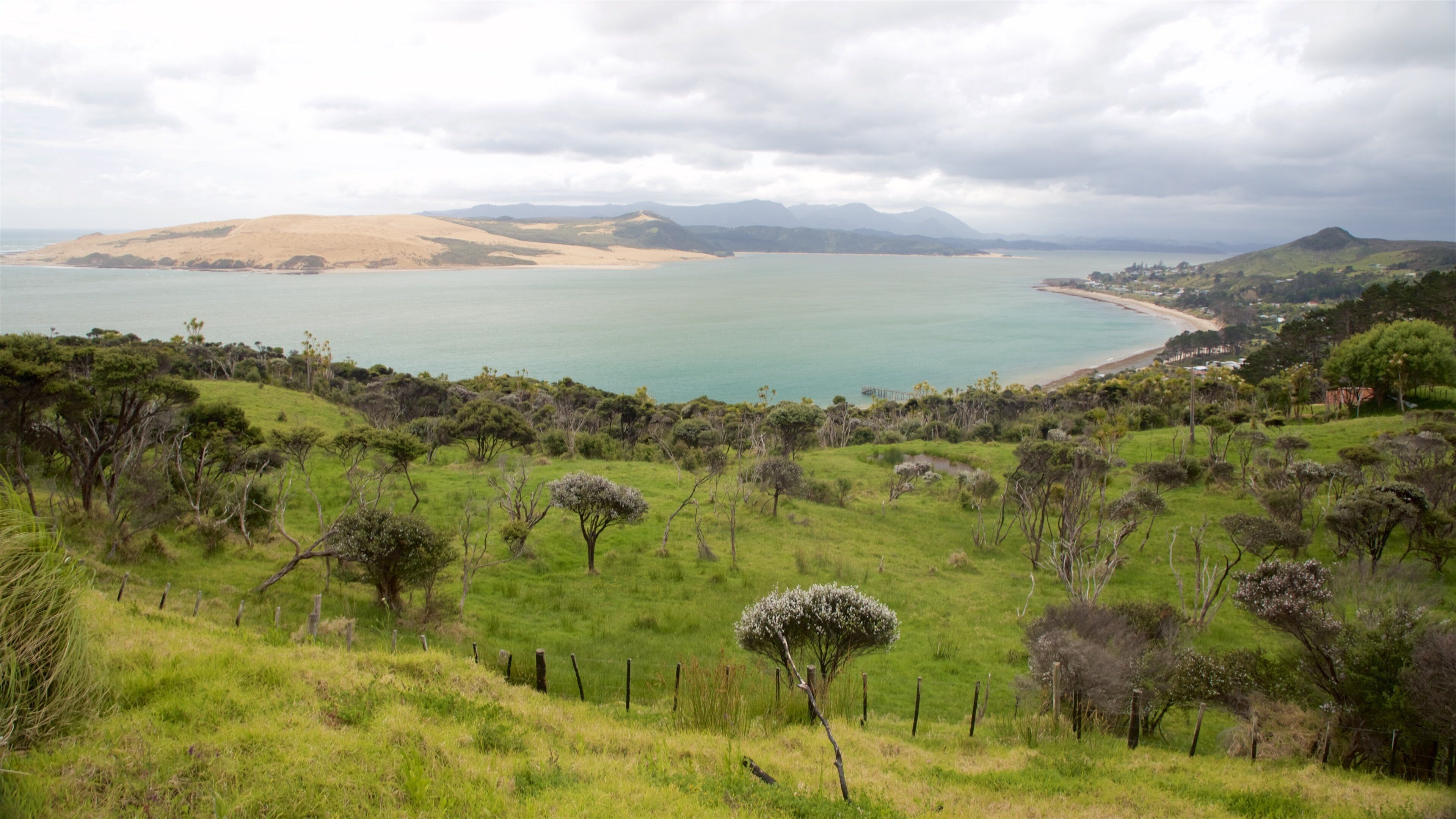 Thị trấn Omapere trong đó bao gồm bãi biển cát, cảnh bờ biển và cảnh thanh bình