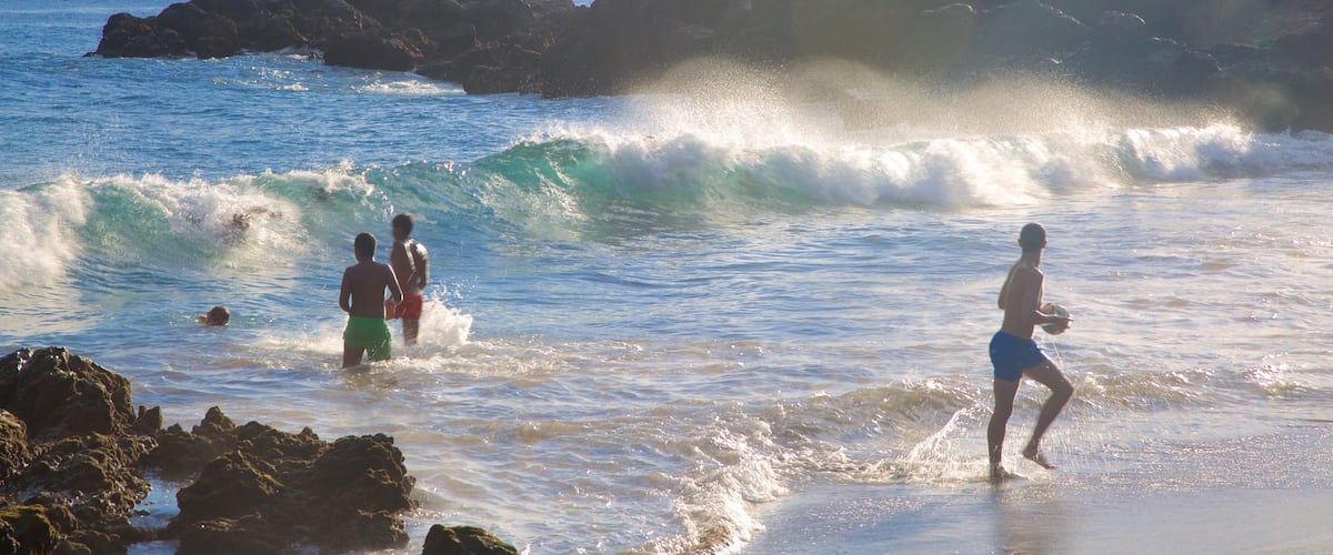 Playa Chica which includes general coastal views, a sunset and waves
