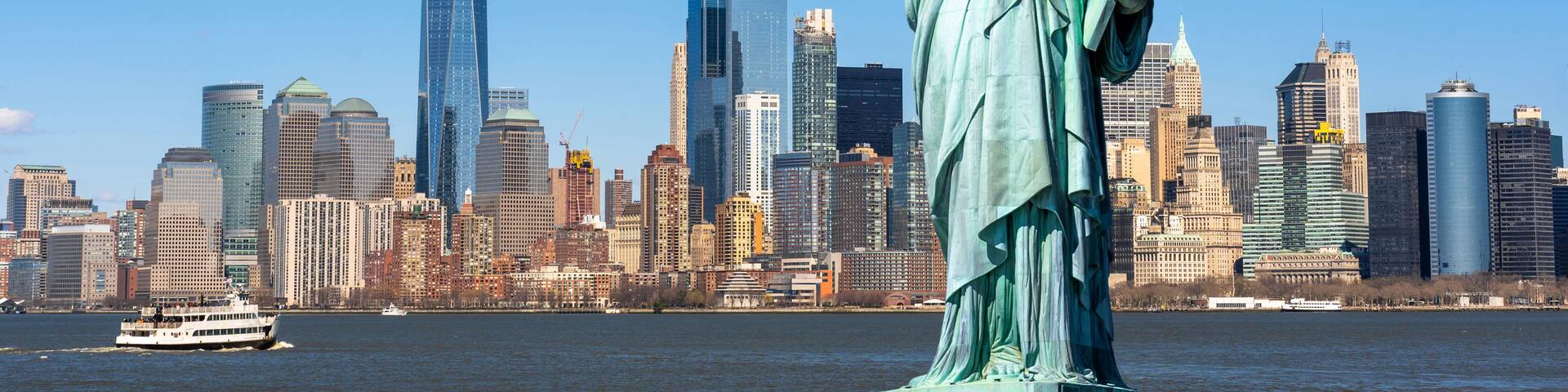 The Statue of Liberty in New York City with the Manhattan skyline in the background.