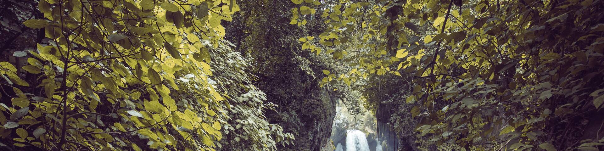 Bridge of God Waterfalls San Luis Potosí - January 19, 2020: beautiful woman on a rock watching the waterfall and the turquoise blue pond