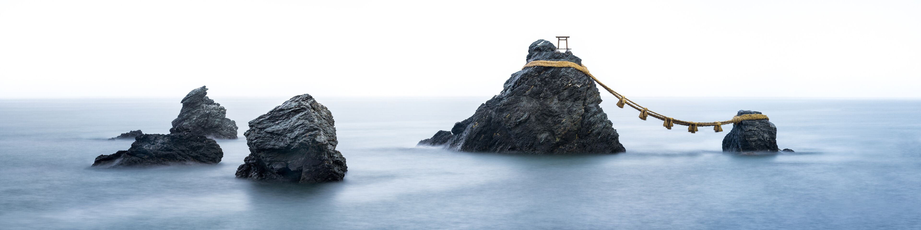 A series of rock formations with a rope bridge connecting them.
