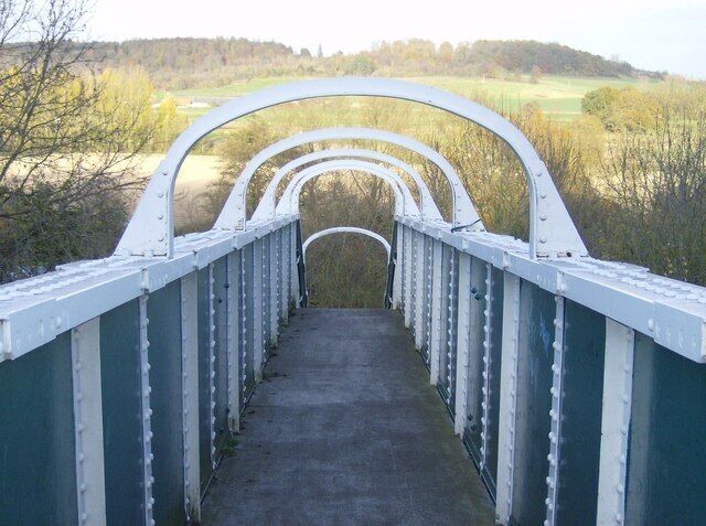 Railway footbridge by the Roebuck Hotel This view is north. The bridge runs off the Oxford Road to the south on the level, with a steep drop beyond the railway down to the River Thames. On the north bank, rural Oxfordshire. Park Wood and Chazey Wood, in the next squares, can be seen.