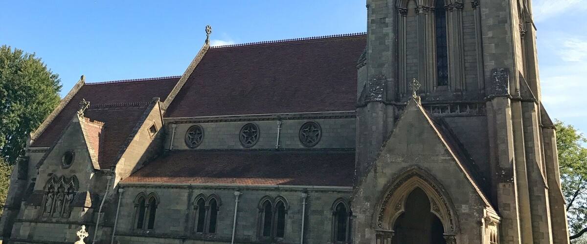A historic church with a tall spire and a large clock tower.