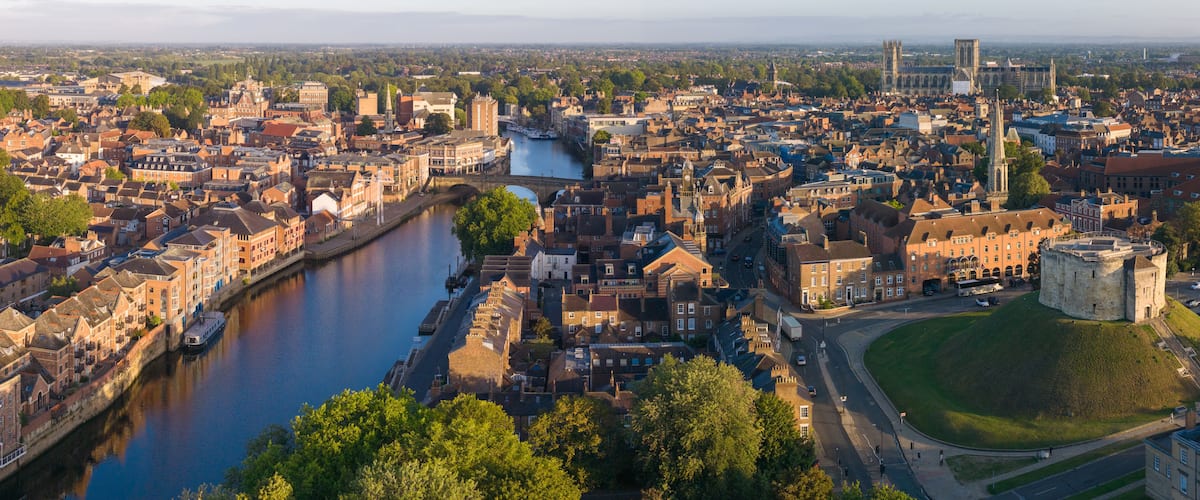 A river winding through a historic city with notable architecture and a prominent church.