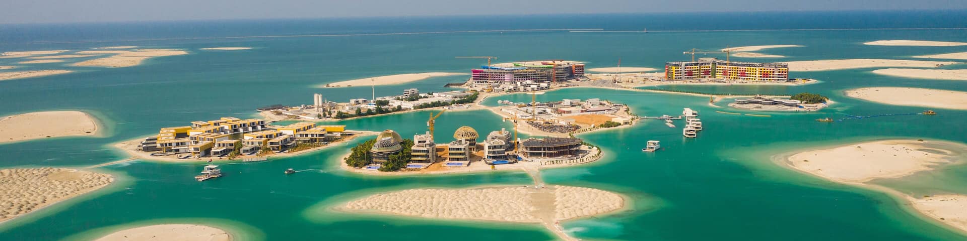 A coastal resort with multiple islands connected by bridges, featuring clear turquoise waters and sandy beaches.