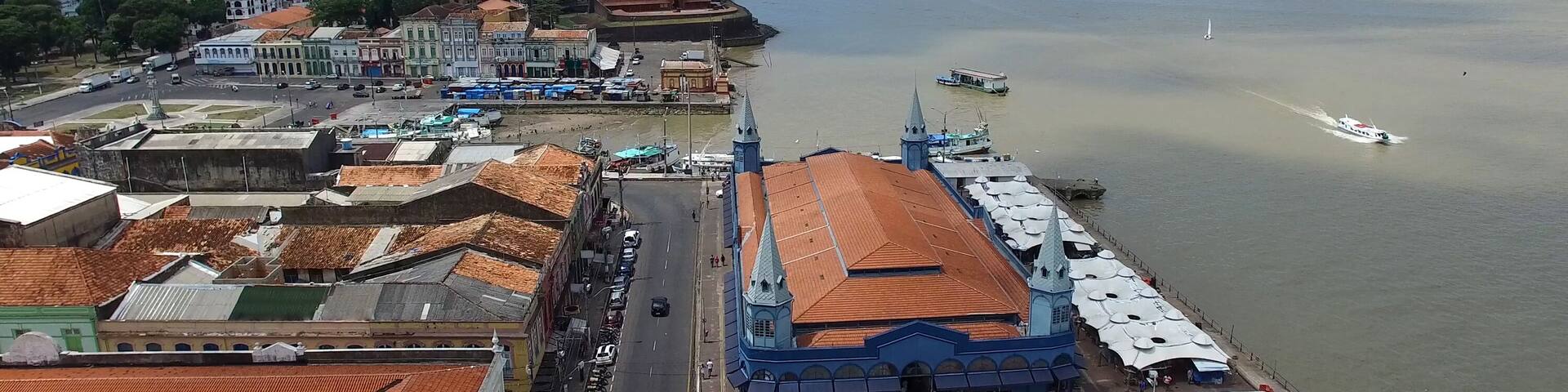 A coastal cityscape with a prominent church, a river, and a bridge.