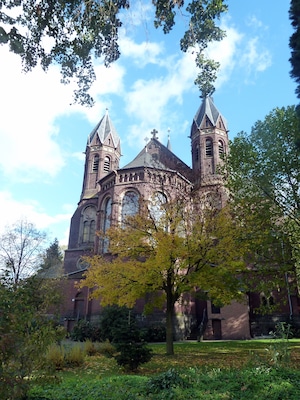 Eine historische Kirche mit zwei Türmen und einem großen Bogenfenster.