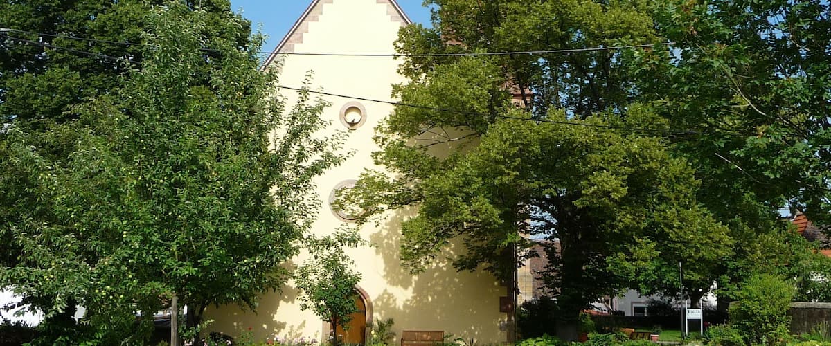 A church with a tall spire and a smaller building with a clock tower.