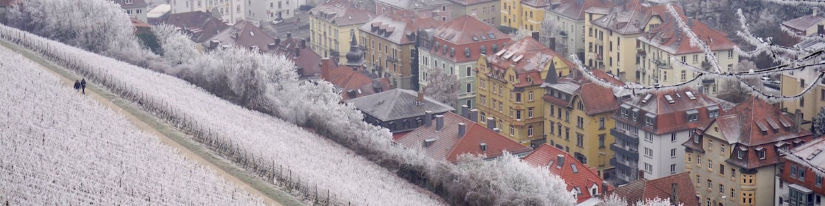 A snow-covered town with buildings along a river.