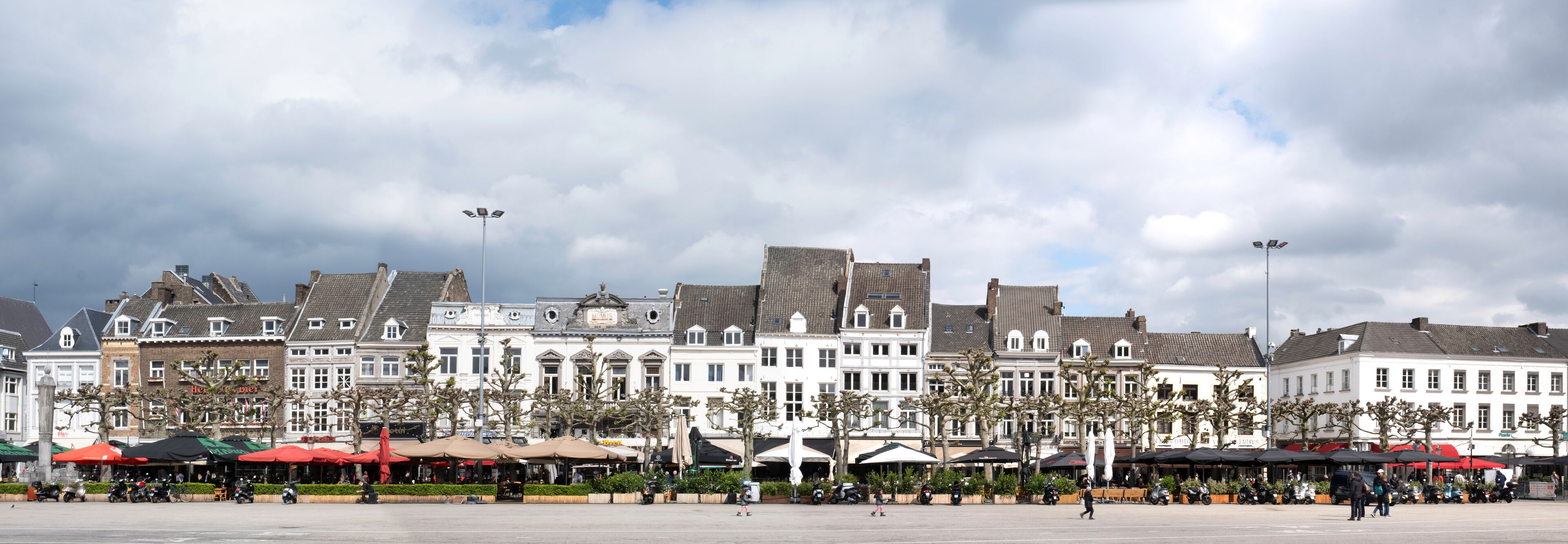Une place historique au cœur de l’Europe, bordée de bâtiments traditionnels, de cafés en plein air et offrant une vue sur un ciel dégagé.